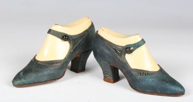 A pair of early 20th century gilt tooled blue leather shop display lady's shoes of diminutive