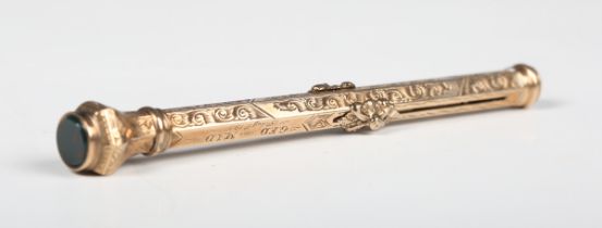 A gold cased hexagonal slide-action dip pen/pencil with scroll engraved decoration and a