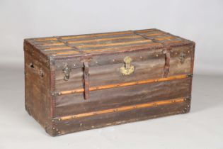A late 19th century canvas covered and wooden bound travelling trunk, height 56cm, width 111cm,