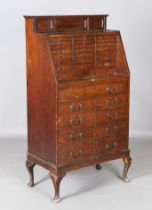 An early 20th century oak bank of drawers, the top gallery fitted with two doors above an