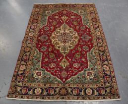 A Tabriz rug, Central Persia, late 20th century, the puce field with a bold ivory medallion and