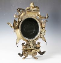 A late 19th century cast brass dressing table mirror, the shaped frame with a clown surmount, the