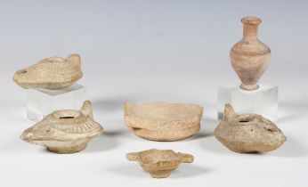 A small group of pottery antiquities, including three Roman oil lamps and a small urn, height 8cm.