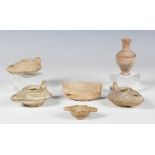 A small group of pottery antiquities, including three Roman oil lamps and a small urn, height 8cm.