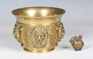 A late 20th century turned brass mortar, decorated in relief with lions' masks, diameter 14cm,