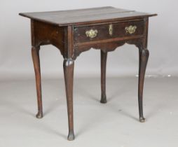 A Queen Anne provincial oak lowboy, fitted with a single drawer, on cabriole legs and pad feet,