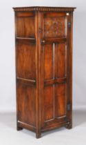 A late 20th century Jacobean Revival oak hall cupboard, fitted with a carved panel door, height