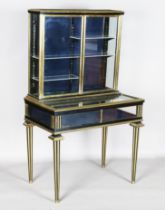 A late 19th century ebonized and brass mounted bijouterie cabinet, fitted with two glazed doors