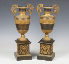 A pair of early 19th century brown patinated and gilt metal mounted ornamental urns, in the manner