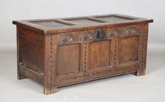 An early 18th century panelled oak coffer, the lid with original wire hinges, the front carved