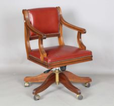 A modern George III style mahogany revolving desk armchair, upholstered in claret leather, height