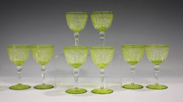 A set of eight lime green flashed and cut uranium glass wines, early 20th century, the rounded bowls