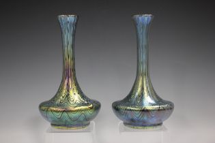 A matched pair of Loetz Phaenomen iridescent glass vases, circa 1900, the ruby red bodies with