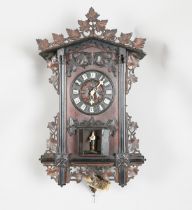 A late 19th century Black Forest carved oak trumpeter wall clock, the weight driven two train