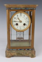 An early 20th century French brass, onyx and champlevé enamel four glass mantel clock with eight day