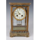 An early 20th century French brass, onyx and champlevé enamel four glass mantel clock with eight day
