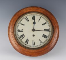 An early 20th century oak circular cased wall timepiece, the 8-inch painted circular dial with black