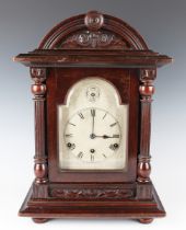 A late 19th century walnut cased mantel clock with three train eight day movement chiming on