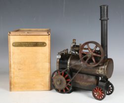 A portable steam engine, probably Doll & Co, with chimney, three-wick burner, flywheel with single