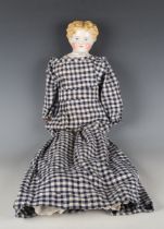 A German porcelain head and shoulders doll with painted moulded hair, facial features and cloth