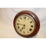 An old wall clock with painted circular dial in polished stained wood circular case