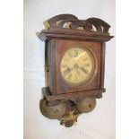 A late 19th century German wall clock with circular dial in polished wood case above twin bells