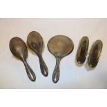 A George V silver five-piece dressing set comprising a pair of hair brushes,