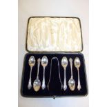 A set of six Edward VII silver teaspoons with decorated handles and matching sugar tongs,