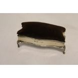 An Edward V11 silver rectangular ring box with hinged pin cushion top on scroll legs,