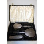 An EIIR silver four piece dressing set comprising hand mirror, hair brush, clothes brush and comb,