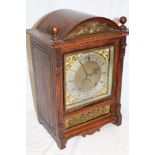A German bracket clock with gilt and silvered square dial in carved oak and brass mounted arched