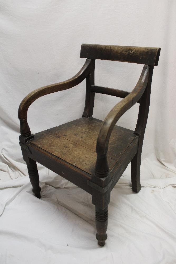 An early 19th century elm and oak carver armchair with rail back and plain seat on turned legs