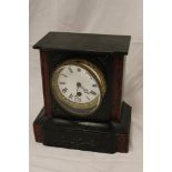 A Victorian mantel clock with circular enamelled dial in black slate and marble angular case