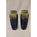 A pair of Royal Doulton pottery tapered vases with floral decorated necks on blue ground,