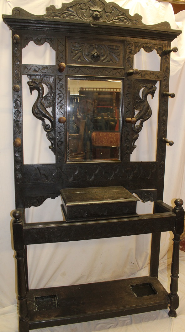 A Victorian carved oak traditional hall stand with central bevelled mirrored panel and glove box