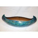 A CH Brannam of Barnstaple pottery bowl in the form of a canoe with raised stylised floral