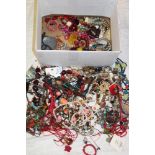 A box containing a large selection of costume jewellery including necklaces, brooches, dress rings,
