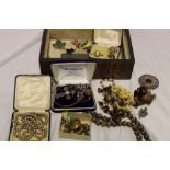 A jewellery box containing a quantity of various costume jewellery including brooches,