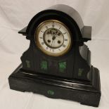 A late Victorian mantel clock with enamelled circular dial and part visible escapement in black