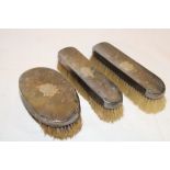 A pair of George V silver clothes brushes with engraved initials and a matching oval hair brush,