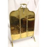 An Edwardian 1920's brass arched fire screen with loop handle,