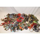 A box containing various costume jewellery including necklaces, brooches,