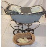 A vintage painted metal child's pram containing a modern doll together with a wicker crib