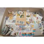 A box containing various World stamps on/off paper