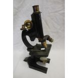 A brass and painted metal monocular microscope by R & J Beck of London in fitted case with