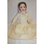 A large porcelain headed child's doll with sleeping eyes and open mouth marked "C.P.