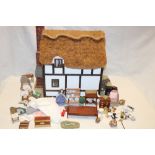 A good quality wooden constructed thatched cottage doll's house together with a selection of