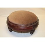 A Victorian mahogany circular foot stool with upholstered seat on turned legs