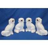 Two pairs of Staffordshire pottery white glazed seated spaniel figures with painted faces 11" and