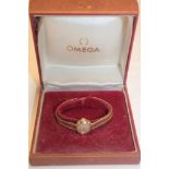 A ladies' 9ct gold wristwatch by Omega with 9ct gold strap, cased (14.
